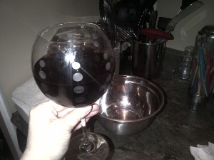 A glass of Kim Crawford pinot noir and a bowl of water leak.